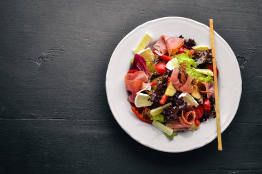 Sebze salatası ve doğranmış et. Ahşap bir arka plan üzerinde. Üstten Görünüm. Boş alan.