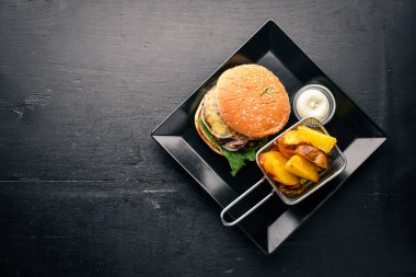 Sığır eti burger. Patates kızartma. Ahşap bir arka plan üzerinde. Üstten Görünüm. Metin için boş alan.