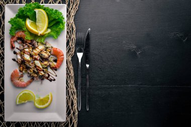 Soğuk aperatifler. Deniz ürünleri, karides, midye, kalamar, ahtapot. Ahşap bir arka plan üzerinde. Üstten Görünüm. Boş alan.