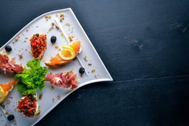 Bruschetta sandviç somon ve hamoon. Ahşap bir arka plan üzerinde. Üstten Görünüm. Boş alan.