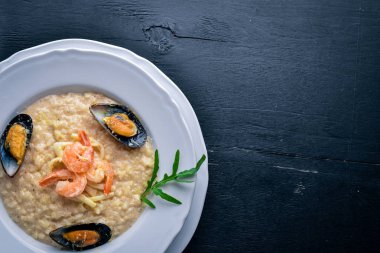 Deniz ürünleri, karides, midye ve mürekkep ve peynirli risotto. Ahşap bir arka plan üzerinde. Üstten Görünüm. Boş alan.