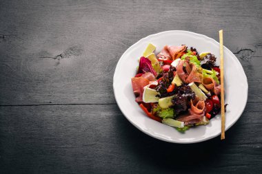 Sebze salatası ve doğranmış et. Ahşap bir arka plan üzerinde. Üstten Görünüm. Boş alan.