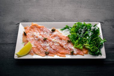 Somon carpaccio. Ahşap bir arka plan üzerinde. Üstten Görünüm. Boş alan.