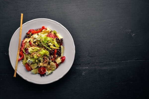 Salad of fresh vegetables and gorgonzola cheese. On a wooden background. Top view. Free space.