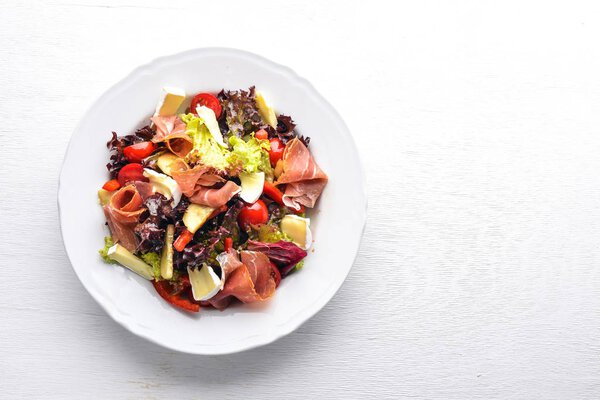 Vegetable salad and diced meat. On a wooden background. Top view. Free space.