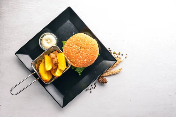 Beef burger. Potatis stekning. På en trä bakgrund. Ovanifrån. Ledigt utrymme för text. — Stockfoto