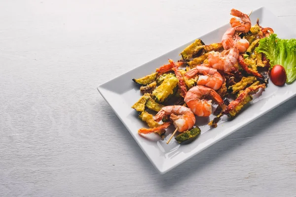 Langostinos reales asados con verduras a la parrilla. Sobre un fondo de madera. Vista superior. Espacio libre . — Foto de Stock