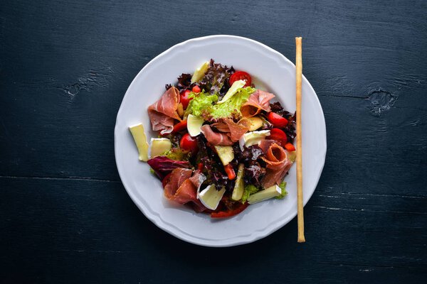 Vegetable salad and diced meat. On a wooden background. Top view. Free space.