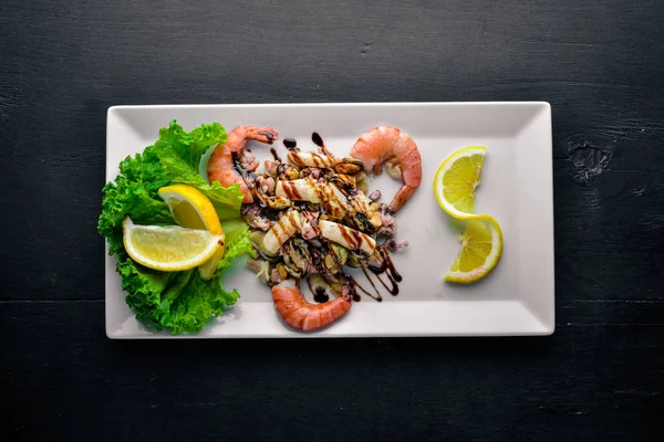 Snacks fríos. Mariscos, camarones, mejillones, calamares, pulpo. Sobre un fondo de madera. Vista superior. Espacio libre . — Foto de Stock