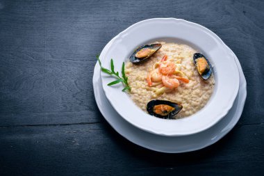 Deniz ürünleri, karides, midye ve mürekkep ve peynirli risotto. Ahşap bir arka plan üzerinde. Üstten Görünüm. Boş alan.