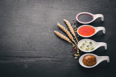 Baharat ve soslar kümesi. Ahşap bir arka plan üzerinde. Üstten Görünüm. Metin için boş alan.