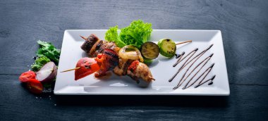 Dana eti kebap, domuz eti ve ızgara sebze. Ahşap bir arka plan üzerinde. Üstten Görünüm. Boş alan.