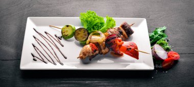 Dana eti kebap, domuz eti ve ızgara sebze. Ahşap bir arka plan üzerinde. Üstten Görünüm. Boş alan.