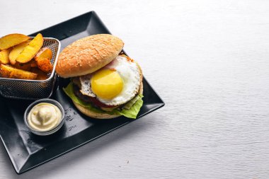 Kahvaltı. Patates kızartması ve burger et ve yumurta. Ahşap bir arka plan üzerinde. Üstten Görünüm. Boş alan.