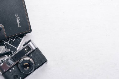 Kamera, dizüstü bilgisayar, göz mercekleri ve kalem ile Office çalışma alanı. Bir ahşap yüzeye. Üstten Görünüm. Metniniz için boş alan.