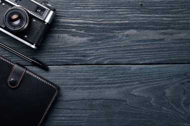 Kamera, dizüstü bilgisayar, göz mercekleri ve kalem ile Office çalışma alanı. Bir ahşap yüzeye. Üstten Görünüm. Metniniz için boş alan.