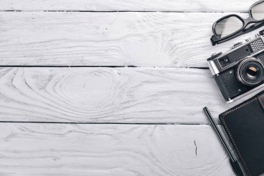 Kamera, dizüstü bilgisayar, göz mercekleri ve kalem ile Office çalışma alanı. Bir ahşap yüzeye. Üstten Görünüm. Metniniz için boş alan.