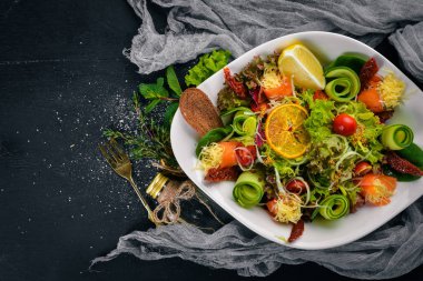 Tuzlanmış somon, peynir ve salata yaprakları salata. Bir ahşap yüzeye. Üstten Görünüm. Metniniz için boş alan.