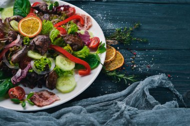 Domuz eti ve tavuk karaciğer salata. Bir ahşap yüzeye. Üstten Görünüm. Metniniz için boş alan.