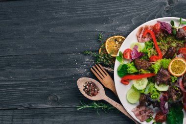 Domuz eti ve tavuk karaciğer salata. Bir ahşap yüzeye. Üstten Görünüm. Metniniz için boş alan.