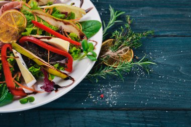 Et ve salata salata yaprakları. Bir ahşap yüzeye. Üstten Görünüm. Metniniz için boş alan.