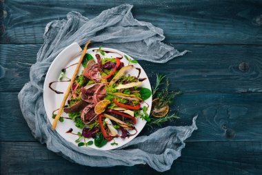 Et ve salata salata yaprakları. Bir ahşap yüzeye. Üstten Görünüm. Metniniz için boş alan.