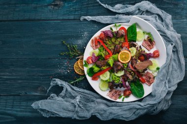 Domuz eti ve tavuk karaciğer salata. Bir ahşap yüzeye. Üstten Görünüm. Metniniz için boş alan.