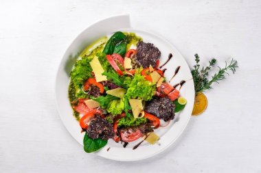 Biftek salata ve taze sebze. Bir ahşap yüzeye. Üstten Görünüm. Metniniz için boş alan.