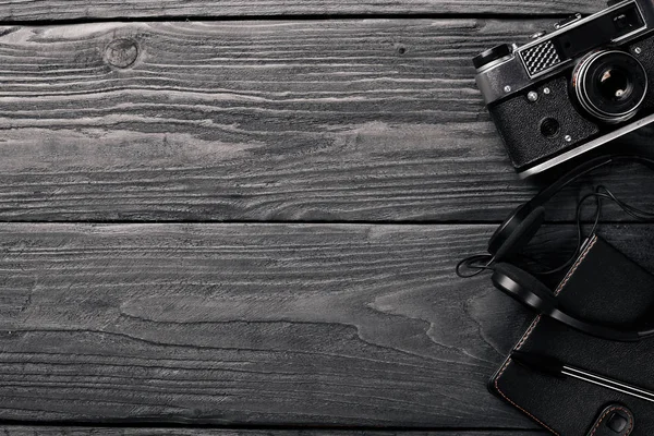 Office work space with camera, notebook, eyepieces, and pen. On a wooden surface. Top view. Free space for your text. — Stock Photo, Image