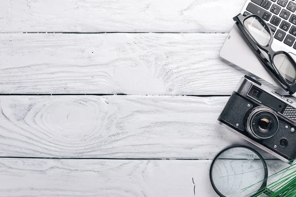 Office arbetsplats med kamera, notebook, okular och penna. På en yta av trä. Ovanifrån. Fritt utrymme för din text. — Stockfoto