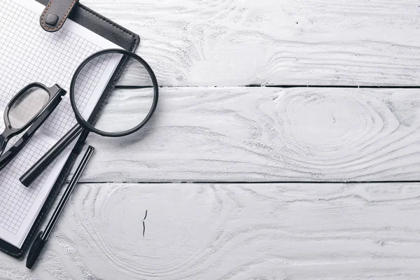 Office work space, notebook, laptop and glasses. On a wooden surface. Top view. Free space for your text.