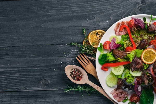 Domuz eti ve tavuk karaciğer salata. Bir ahşap yüzeye. Üstten Görünüm. Metniniz için boş alan.