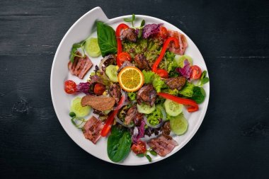 Domuz eti ve tavuk karaciğer salata. Bir ahşap yüzeye. Üstten Görünüm. Metniniz için boş alan.