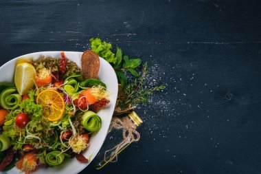 Tuzlanmış somon, peynir ve salata yaprakları salata. Bir ahşap yüzeye. Üstten Görünüm. Metniniz için boş alan.