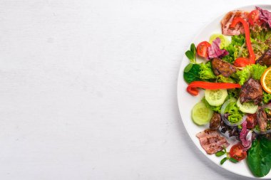 Domuz eti ve tavuk karaciğer salata. Bir ahşap yüzeye. Üstten Görünüm. Metniniz için boş alan.