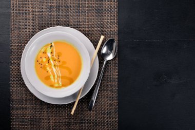 Balkabağı çorbası. Bir ahşap yüzeye. Üstten Görünüm. Metniniz için boş alan.