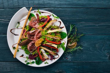 Et ve salata salata yaprakları. Bir ahşap yüzeye. Üstten Görünüm. Metniniz için boş alan.