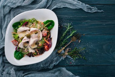 Salata taze sebze ve tavuk fileto. Bir ahşap yüzeye. Üstten Görünüm. Metniniz için boş alan.