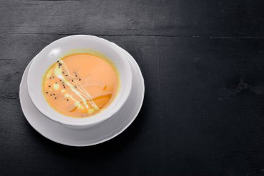 Balkabağı çorbası. Bir ahşap yüzeye. Üstten Görünüm. Metniniz için boş alan.