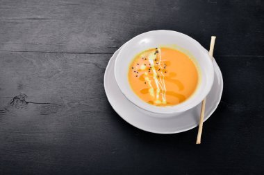 Balkabağı çorbası. Bir ahşap yüzeye. Üstten Görünüm. Metniniz için boş alan.