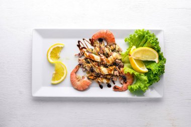 Soğuk aperatifler. Deniz ürünleri, karides, midye, kalamar, ahtapot. Ahşap bir arka plan üzerinde. Üstten Görünüm. Boş alan.