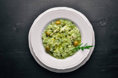 Risotto ıspanak, peynir ve zeytin. Ahşap bir arka plan üzerinde. Üstten Görünüm. Boş alan.