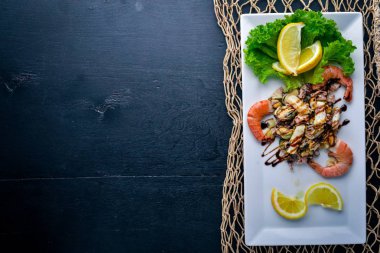 Soğuk aperatifler. Deniz ürünleri, karides, midye, kalamar, ahtapot. Ahşap bir arka plan üzerinde. Üstten Görünüm. Boş alan.