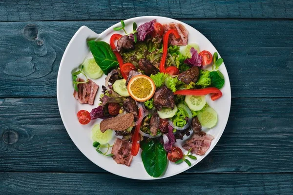 Domuz eti ve tavuk karaciğer salata. Bir ahşap yüzeye. Üstten Görünüm. Metniniz için boş alan. — Stok fotoğraf