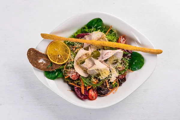 Ensalada de verduras frescas y filete de pollo. Sobre una superficie de madera. Vista superior. Espacio libre para tu texto . — Foto de Stock