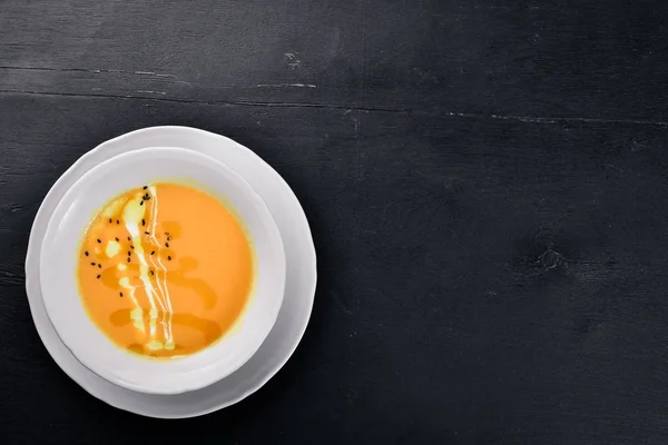 Sopa de abóbora. Em uma superfície de madeira. Vista superior. Espaço livre para o seu texto . — Fotografia de Stock