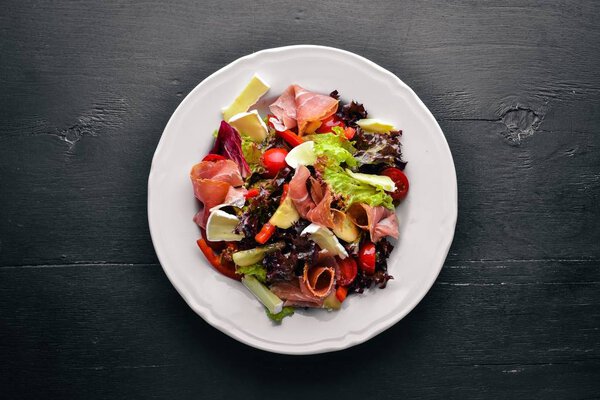 Vegetable salad and diced meat. On a wooden background. Top view. Free space.