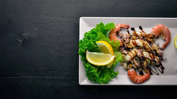 Snacks fríos. Mariscos, camarones, mejillones, calamares, pulpo. Sobre un fondo de madera. Vista superior. Espacio libre . — Foto de Stock