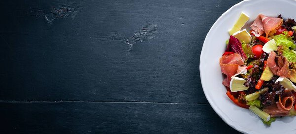 Vegetable salad and diced meat. On a wooden background. Top view. Free space.