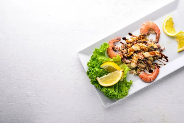 Kalte Snacks. Meeresfrüchte, Garnelen, Muscheln, Tintenfische, Tintenfische. auf einem hölzernen Hintergrund. Ansicht von oben. Freiraum. — Stockfoto